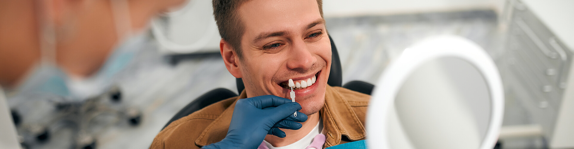 male being shown veneers against his teeth