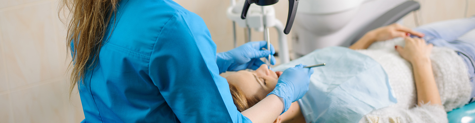 A dentist working with a female patient.
