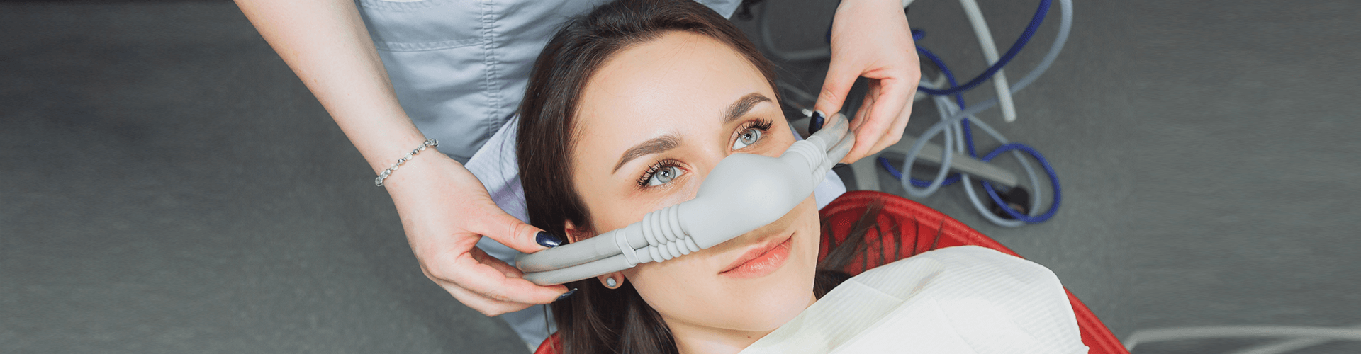 dentist placing breathing mask on patient