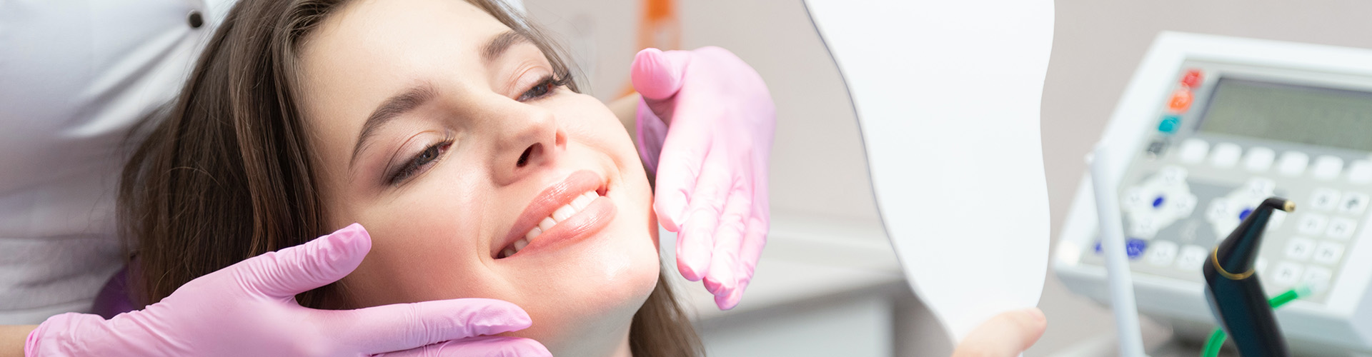 dentist framing mouth of woman smiling into mirror