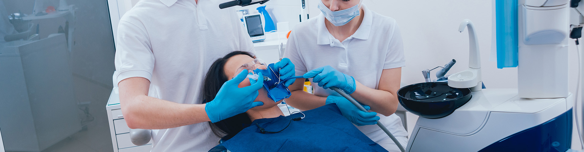 dental staff performing treatment on patient in dental chair